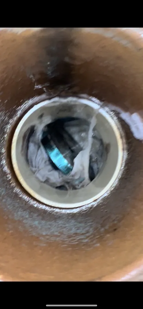 Clogged sewer pipe with debris inside.