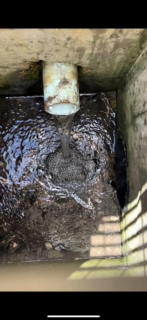 Water flowing from pipe into a concrete basin.
